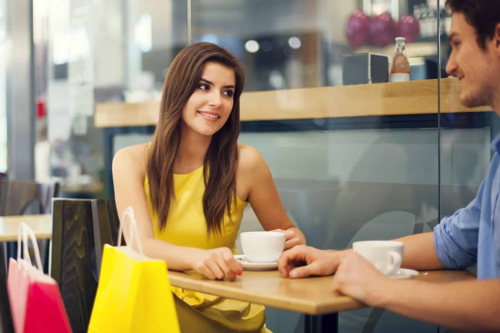 en leende tjej sitter vid ett bord med en man