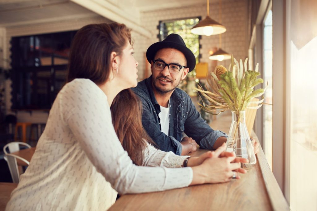 mand og kvinde sidder på en cafe og snakker