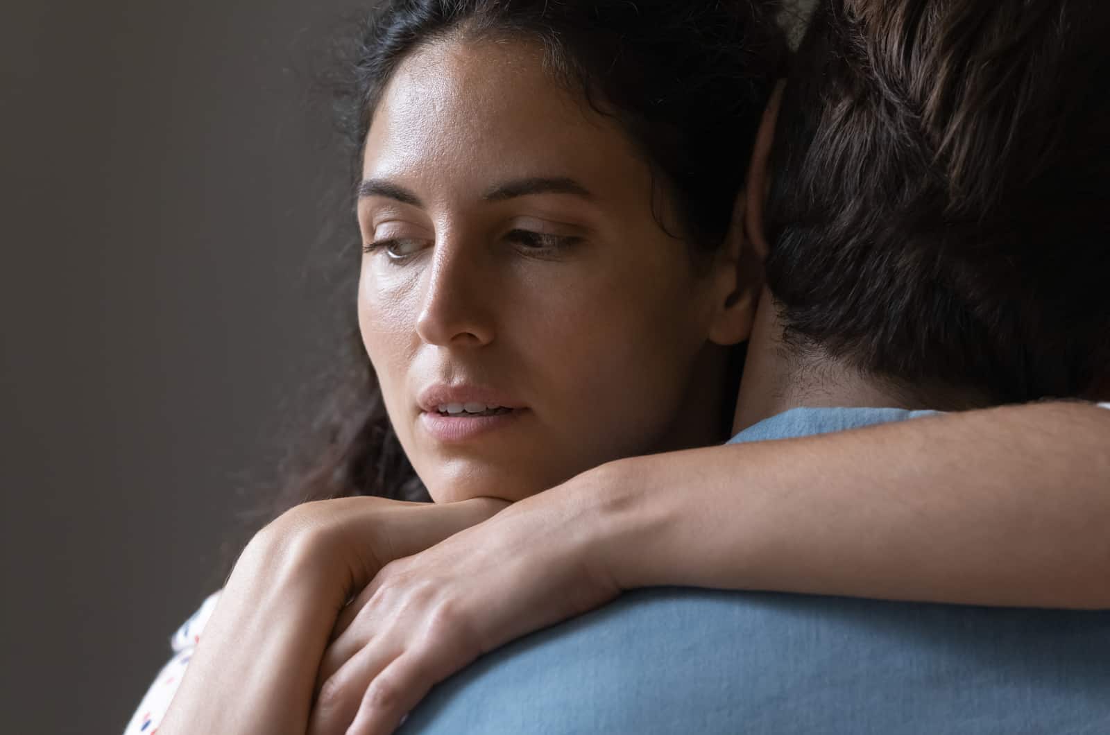 Kvinde krammer sin partner med trist udtryk