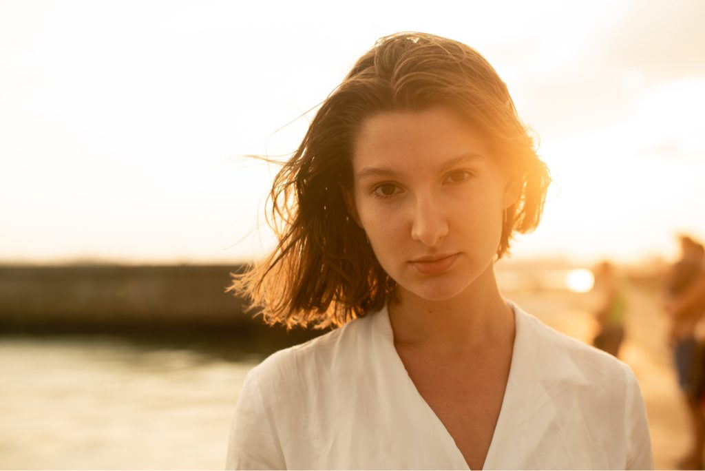 pige i en hvid skjorte ved solnedgang blæser vinden