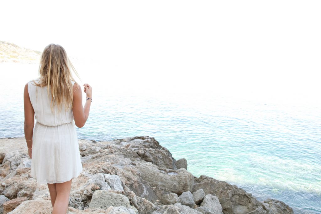 smuk ung blond kvinde på en stenet strand