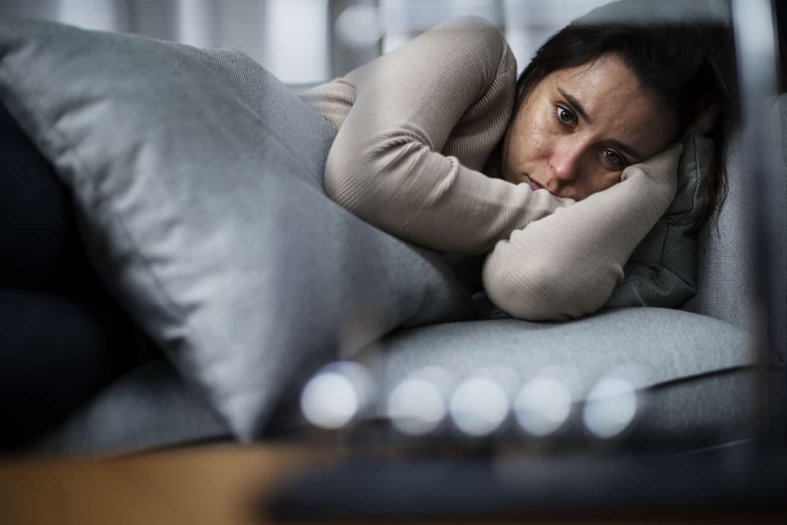 deprimeret kvinde liggende i sengen