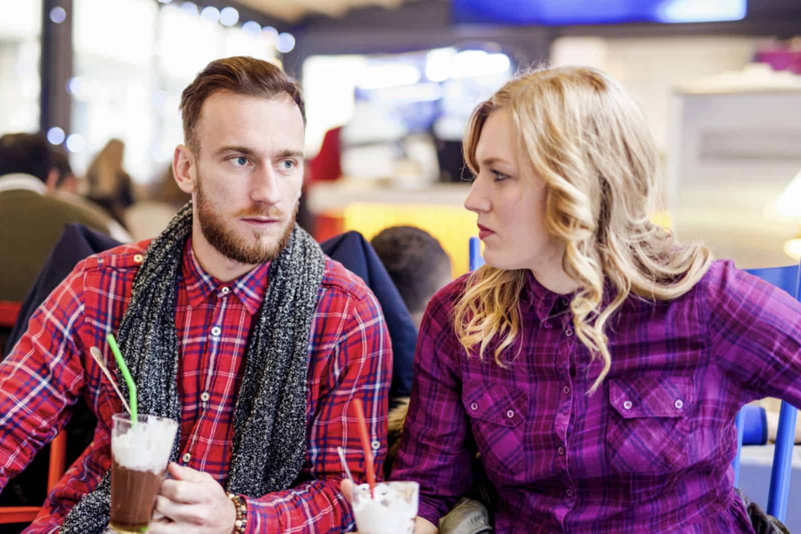 en mann og en kvinne sitter på en restaurant