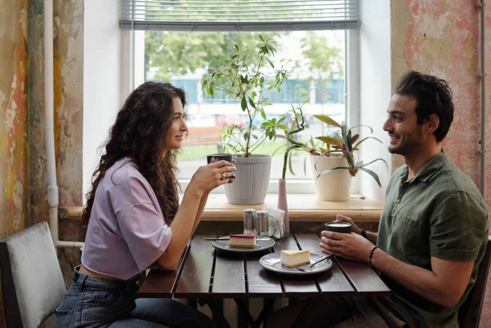 en mann og en kvinne sitter ved bordet og snakker