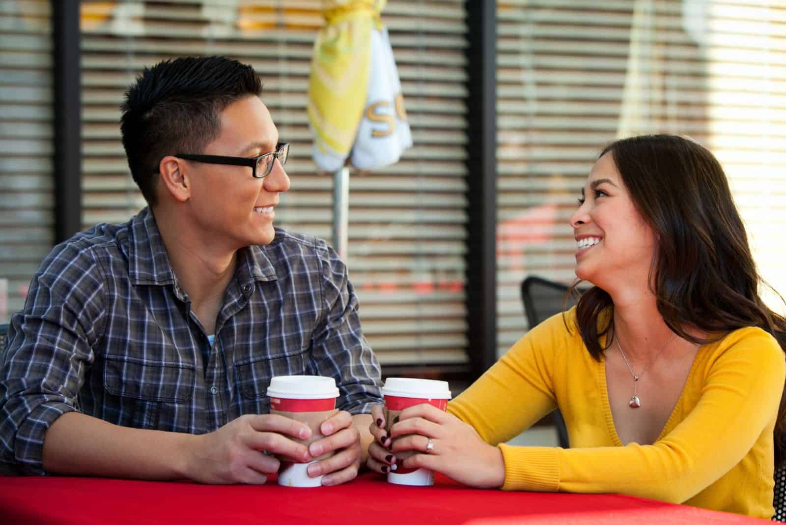 leende älskande par pratar över kaffe