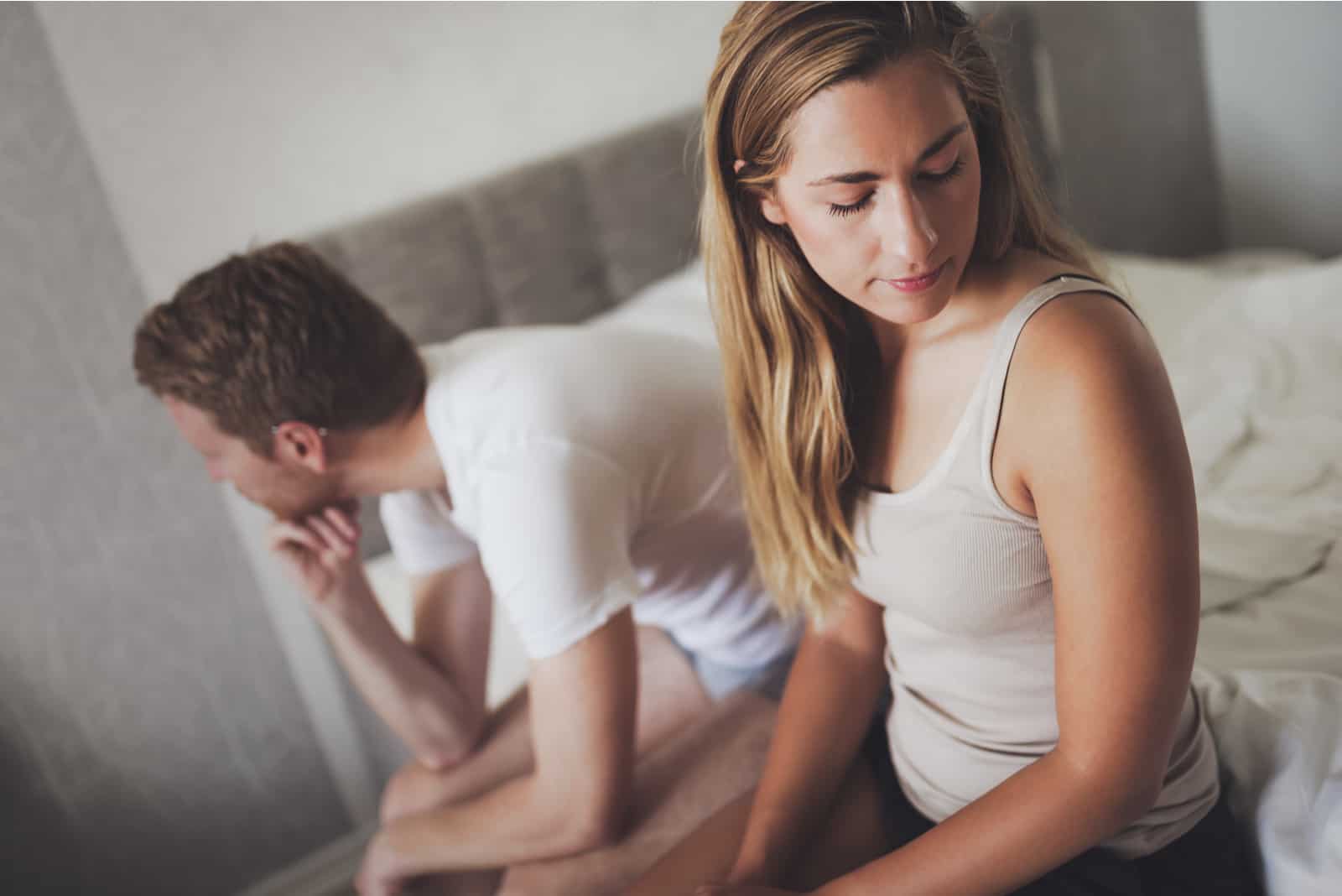 mand og kvinde utilfredse sidder på sengen