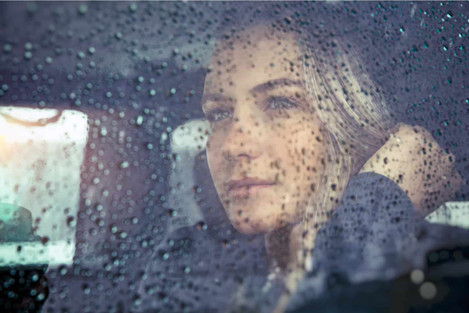 smuk trist kvinde sidder i bilen